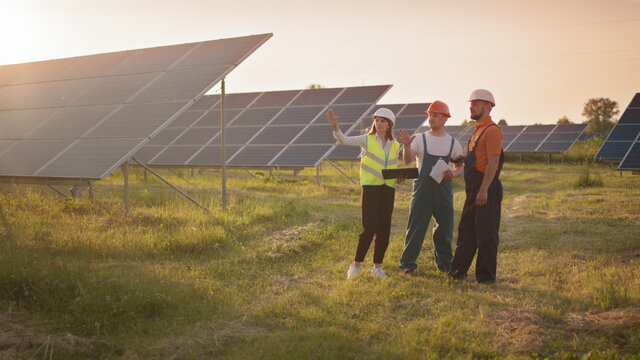 two men and a woman at a solar farm